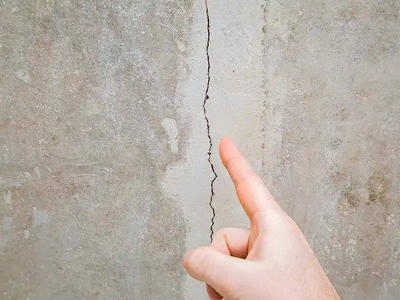 person point to crack in wall