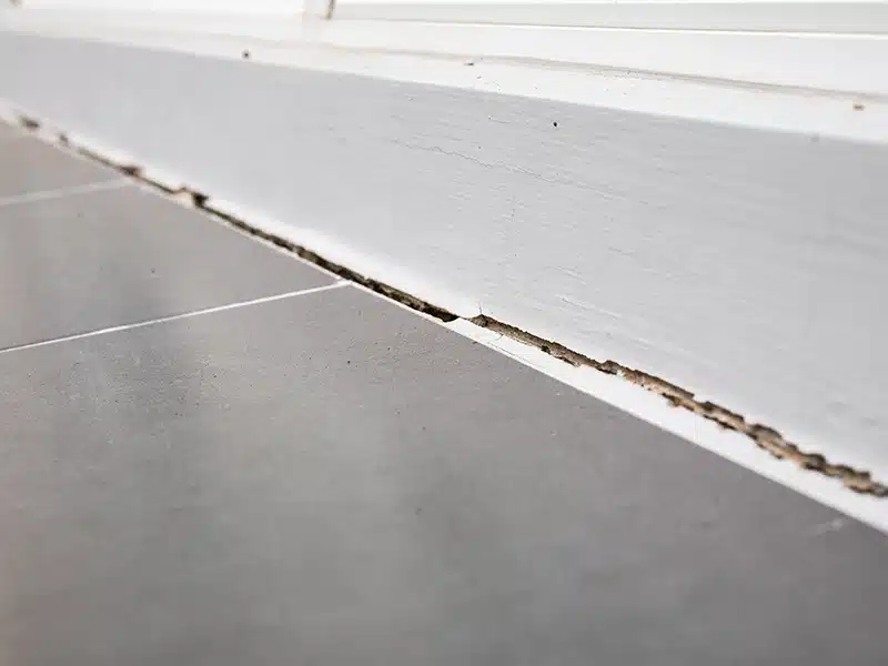 crack in baseboard and floor