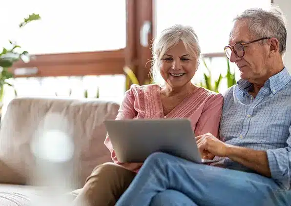 couple sitting on couch looking at paper