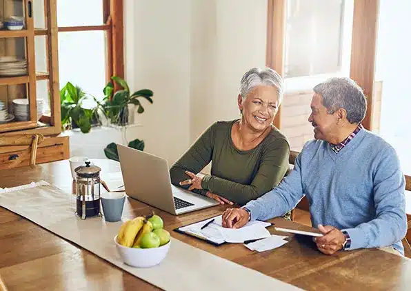 couple sitting at a table looking at a computer